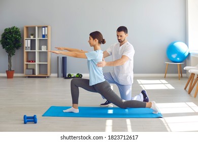 Muscle treatment after traumas. Side view of young female athlete doing forward lunges during visit to physiotherapist. Health center specialist helping woman recover after professional sports injury - Powered by Shutterstock