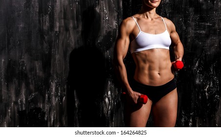 Muscled woman with barbells 