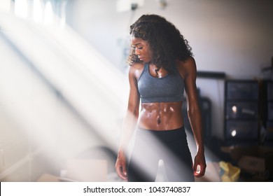 muscular african american woman sweating from work out in home gym