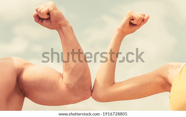 Muscular arm vs weak hand. Vs, fight hard.\
Competition, strength comparison. Rivalry concept. Hand, man arm\
fist Close-up. Rivalry, vs, challenge, strength comparison. Sporty\
man and woman.