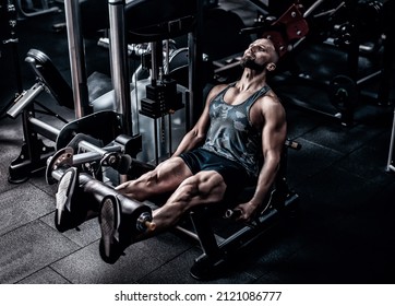 Muscular Athlete Using Weights Machine For Legs At The Gym. Hard Training In Gym