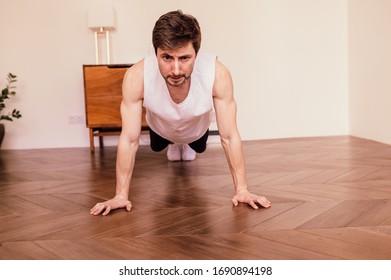 Muscular Athletic Fit Man Is Doing Push Up Exercises At Home In His Bright Apartment With Minimalistic Interior