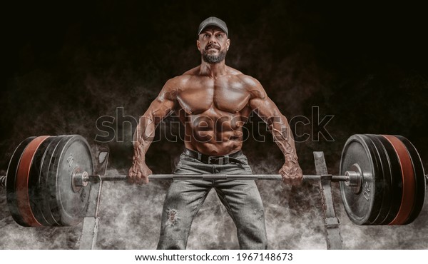 Muscular bearded man lifts a\
barbell. Bodybuilding, fitness, powerlifting concept. Mixed\
media