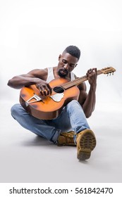 Muscular Black Man Playing Guitar, Wearing Jeans And White Tank-top