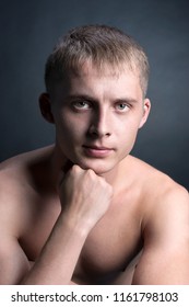 Muscular Blonde Young Handsome Man Topless, Brow Furrowed, Fist Near Face, Looks Straight, Biceps, Sportsman, Studio Light, Low Key, Black Background, Close Up