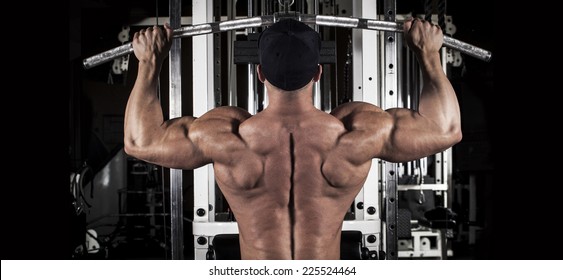 Muscular Body Building Men Training His Back At The Gym 