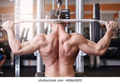 Muscular Body Building Men Training His Back At The Gym