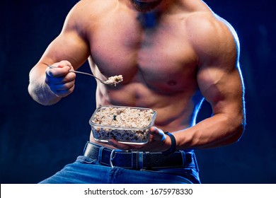 Muscular Bodybuilder Eating Healthy Cereal. Healthy Lifestyle Concept. Naked Torso Athlete On A Chair.