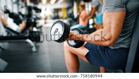 Muscular bodybuilder guy doing exercises