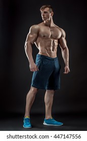 Muscular bodybuilder guy doing posing over black background
