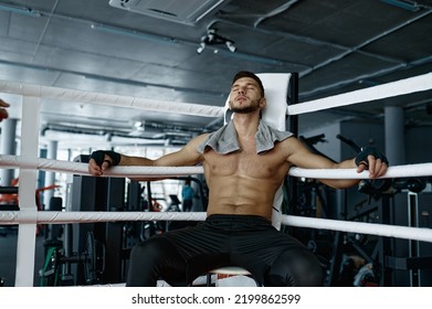 Muscular boxer with towel on shoulders rest in ring corner - Powered by Shutterstock