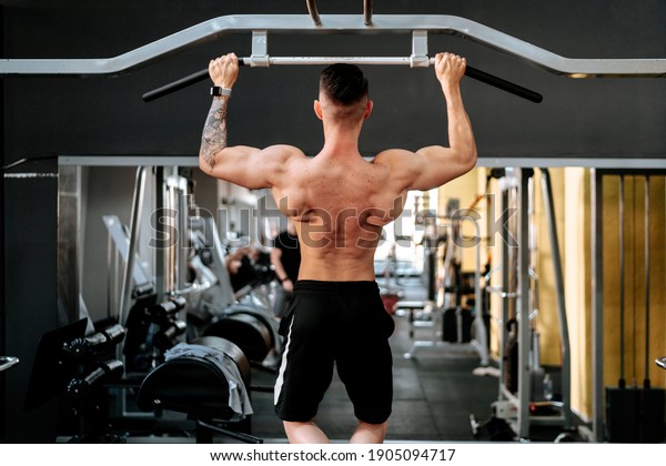 Muscular Built shirtless  Athlete Working Out  in\
gym. Healthy lifestyle\
fitness