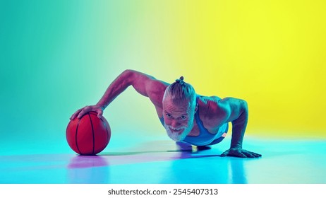 Muscular elderly man in sportswear doing push up exercise with one hand on basketball ball against gradient green yellow background in neon light. Concept of sport, active elderly lifestyle, health - Powered by Shutterstock