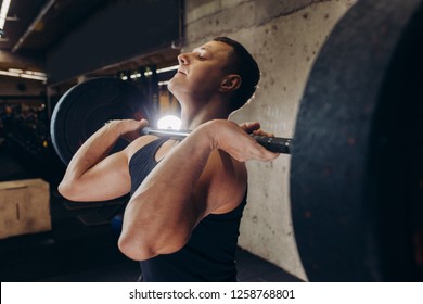 Muscular Fit Guy Training With Barbell. Close Up Side View Photo. Hobby, Lifesyle, Wellness