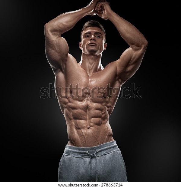 黒い背景にポーズを設定した 筋肉質でフィットな若いボディビルダーフィットネス男性モデル の写真素材 今すぐ編集