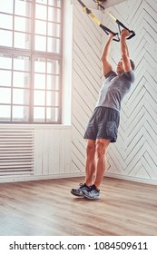 Muscular Fitness Male Doing Exercise With TRX. Functional Workout At Home With TRX Loops.