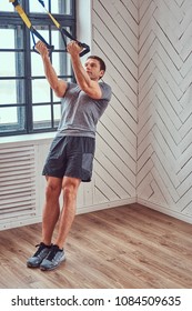 Muscular Fitness Male Doing Exercise With TRX. Functional Workout At Home With TRX Loops.