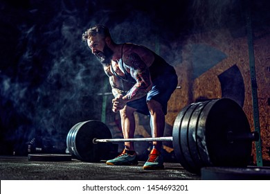 Muscular fitness man preparing to deadlift a barbell in modern fitness center. Functional training. Snatch exercise