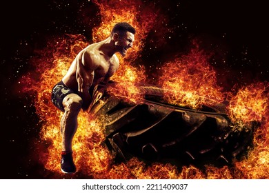 Muscular fitness shirtless man moving large tire in flames, concept lifting, workout cross training.  - Shutterstock ID 2211409037