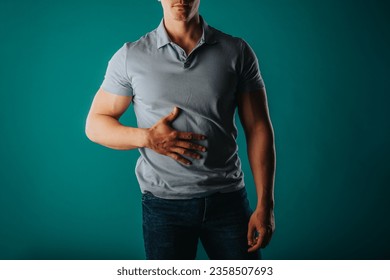 Muscular and good-looking man standing in a green room and posing - Shutterstock ID 2358507693