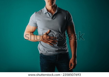 Muscular and good-looking man standing in a green room and posing