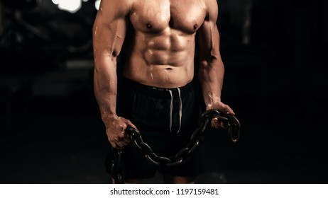 Muscular Guy Holding A Chain. Photo Exercise In The Gym. Go In For Sports. Jock