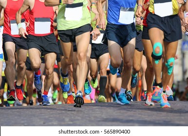 muscular legs of a large number of runners during sports race