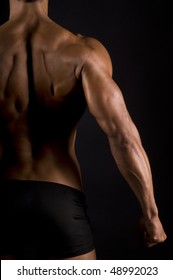 Muscular Male Back On Black Background.