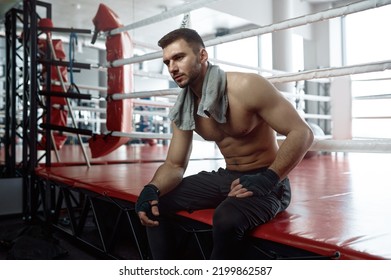 Muscular Male Boxer Sitting On Boxing Ring Mat