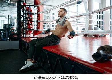 Muscular Male Boxer Sitting On Boxing Ring Mat