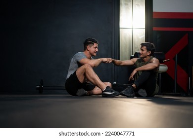 Muscular man athlete in sportswear relaxing and bumping fists hand with friend after exercises at fitness gym. Workout for good health concept. - Powered by Shutterstock