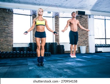 Muscular Man And Beautiful Sporty Woman Workout With Jumping Rope In Crossfit Gym