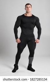 Muscular Man In Black Compression Sportswear On Gray Background