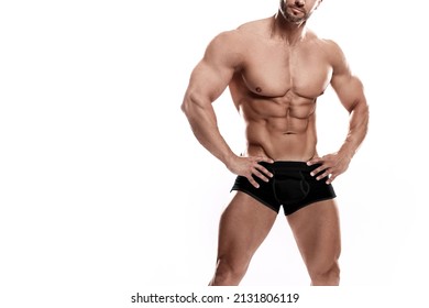 Muscular man bodybuilder wearing black underwear posing against white background