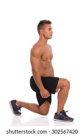 Muscular Man Does A Split Squat, Lunges, Side View. Full Length Studio Shot Isolated On White.