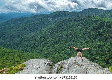 Muscular man doing handstand on the edge of the cliff, North Carolina, Blue Ridge Parkway - Powered by Shutterstock