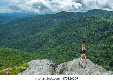 Muscular man doing handstand on the edge of the cliff, North Carolina, Blue Ridge Parkway - Powered by Shutterstock