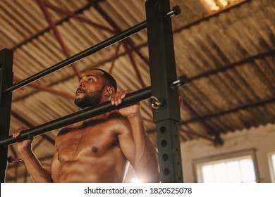 Muscular Man Doing Pull Up Workout On Horizontal Bar In Fitness Studio.  Strong Man Performing Pull Ups On A Horizontal Bar Inside Old And Empty Warehouse.