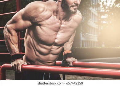 Muscular man during his workout on the street