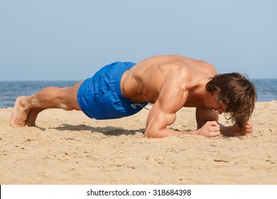 Muscular Man During Workout On The Beach