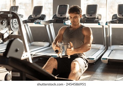 Muscular man exercising in gym, training hard and pulling weights in seated cable row machine. Bodybuilder, fitness concept - Powered by Shutterstock