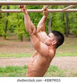 Muscular Man Exercising On Monkey Bars