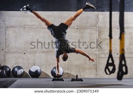 A muscular man in a handstand position, showcasing his exceptional balance and body control while performing a variety of exercises to enhance his overall body stability and strength in a modern gym