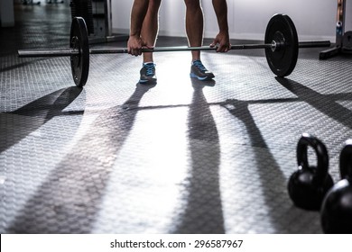 Muscular man lifting a barbell in crossfit gym - Powered by Shutterstock