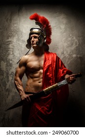 The Muscular Man In Roman Armor Holding Sword.