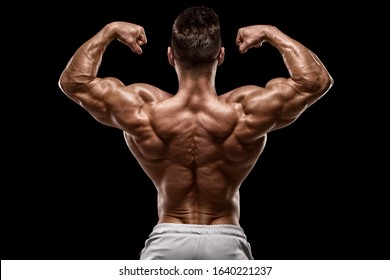 Muscular Man Showing Back Muscles Rear View, Isolated On Black Background. Strong Male Naked Torso