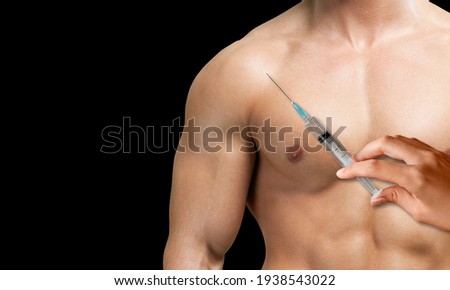 Muscular man with a syringe in doctor hand. Concept of a strength workout and anabolic steroids usage.