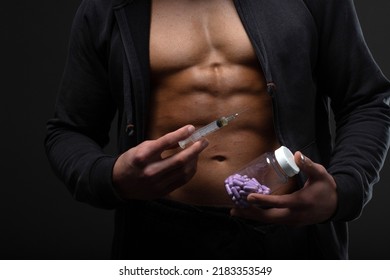Muscular man with a syringe in his hand. User of anabolic steroids for strength training. - Powered by Shutterstock