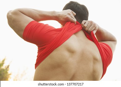 Muscular Man Taking Off His Shirt