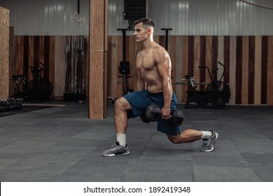 Muscular Man Training His Legs, Doing Lunges With Heavy Dumbbells In Modern Gym. Healthy Lifestyle Concept